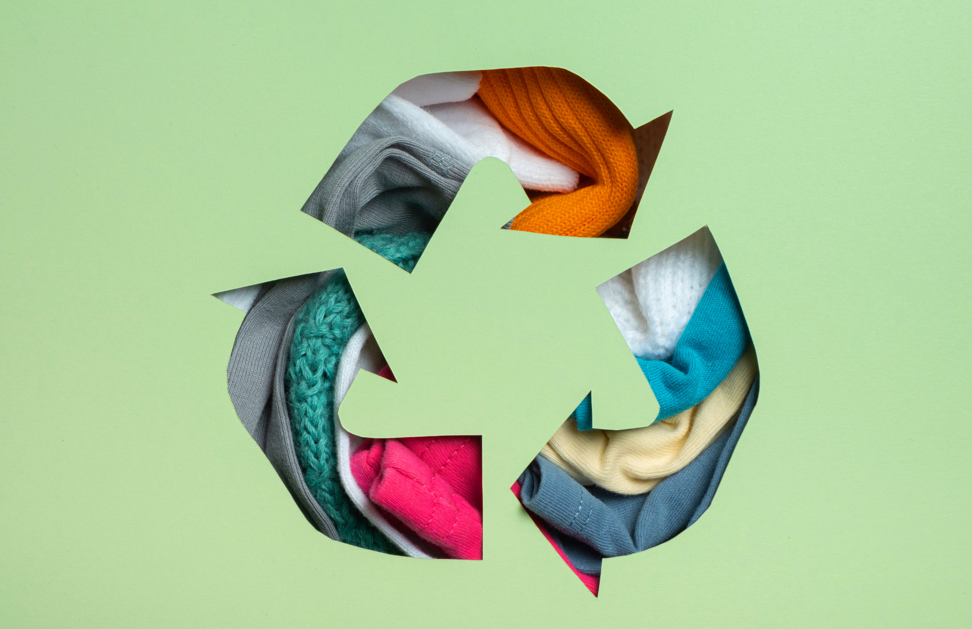 recycling arrors A group of individuals dressed in vibrant sweaters place their hands together in a huddle, embodying the essence of unity and teamwork with people_hands.